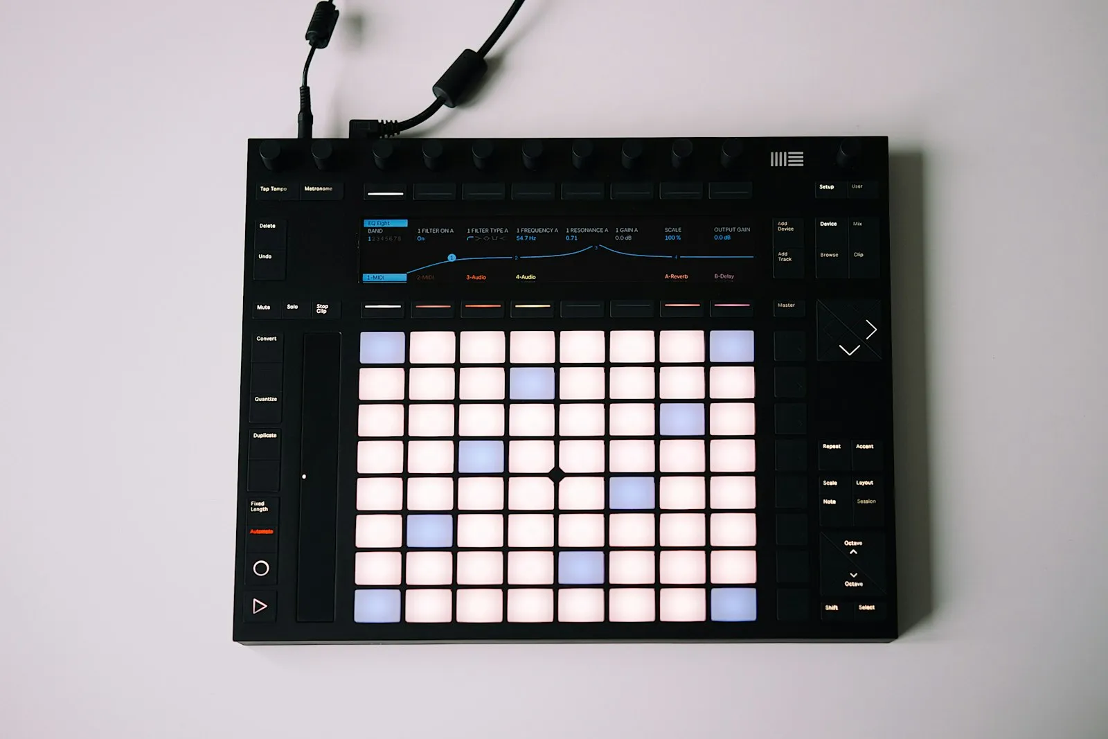 A drum pad controller lit up in a dark studio