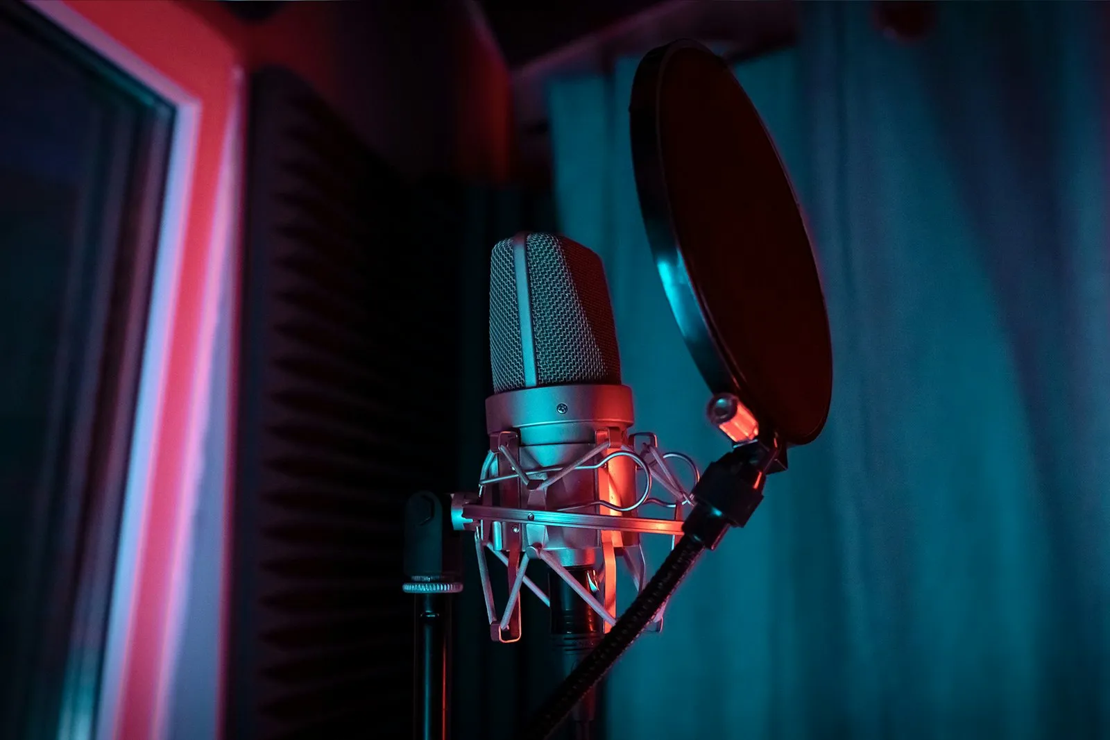 A studio microphone lit by a red light
