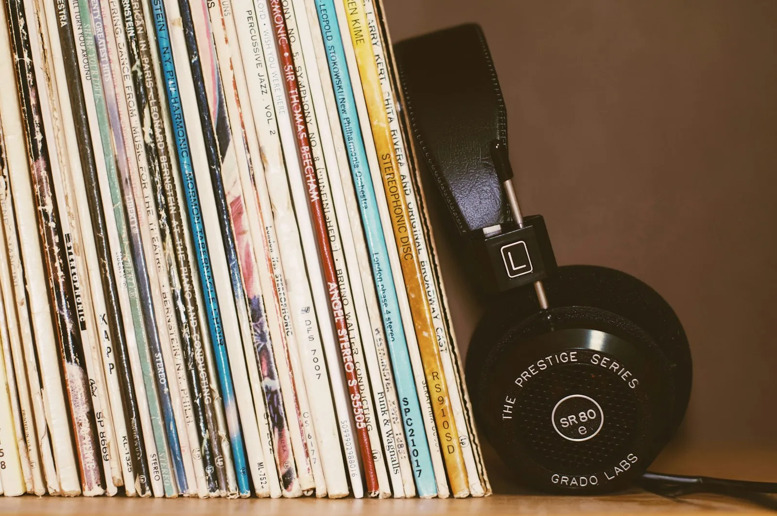 Headphones resting on a stack of vinyl records